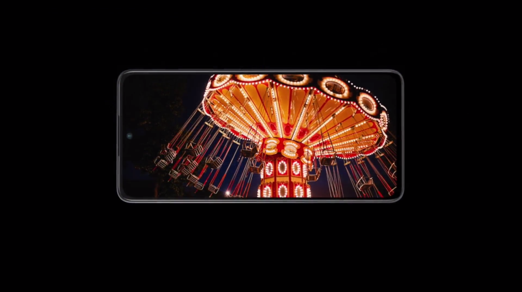 The image shows a smartphone display featuring a brightly lit carnival swing ride against a dark background.